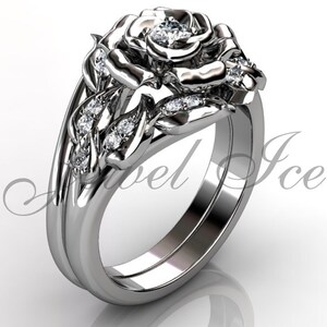 Puede incluir: Un anillo de compromiso de oro blanco en forma de rosa con un diamante central y diamantes m&aacute;s peque&ntilde;os en la banda y los p&eacute;talos de la rosa.