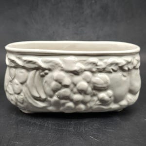 Puede incluir: Taza de cerámica blanca con asa negra y el texto "But First, Coffee" en estilo manuscrito. La taza está sobre una superficie blanca. Para bebidas calientes.