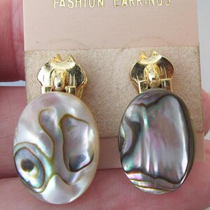 Pendientes con tirador de cremallera perforado con concha de abulón en tono dorado vintage, en tarjeta de la tienda