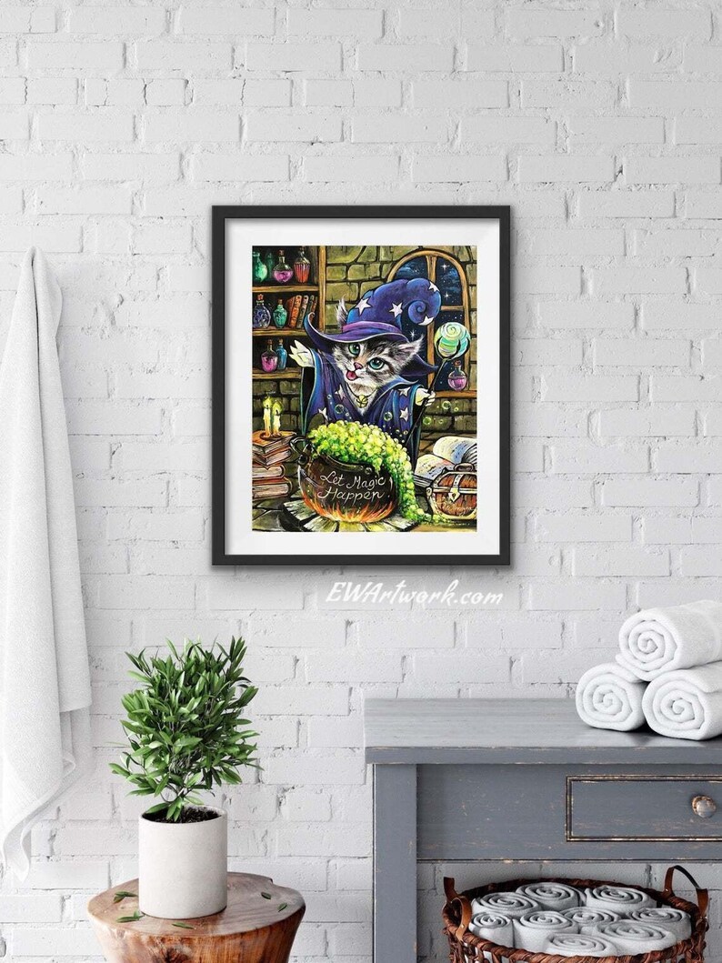 May include: A framed illustration of a cat wearing a wizard hat and holding a wand. The cat is standing in front of a cauldron with green liquid and the text "Let Magic Happen".