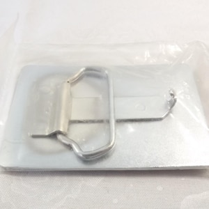 May include: A silver metal belt buckle with a rectangular shape and a simple design. The buckle has a smooth, polished finish and a single, hinged closure.