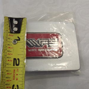 May include: A silver metal emblem with a red and white logo that says "White Farm Equipment".