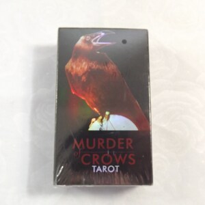 May include: A black box with a red crow on the front. The box says "Murder of Crows Tarot" on the front.