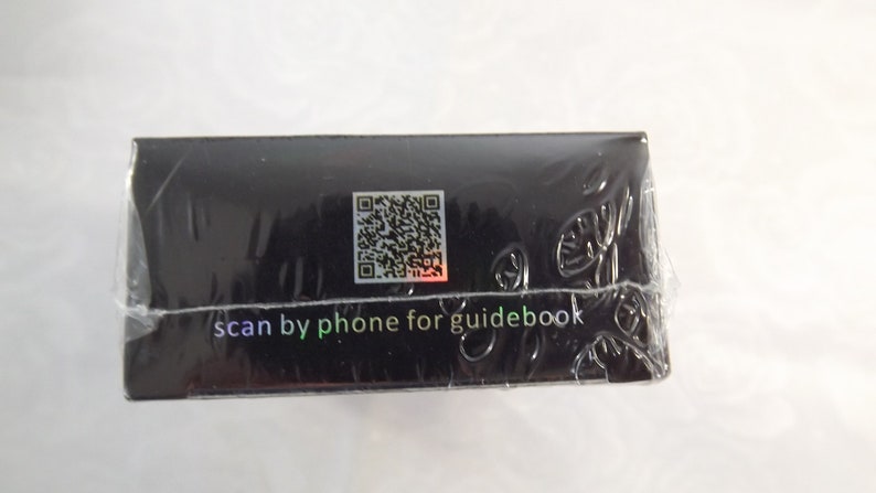 May include: Black box with a QR code and the text "scan by phone for guidebook".