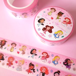 Washi tape with a pattern of mini Disney Princesses on pink background. Two rolls with their envelope, and two are extended showing characters like Kida, Raya, Jane, Aurora, Jasmine, Ariel, Alice, Esmeralda, Amelia, Elsa, Moana, Giselle...