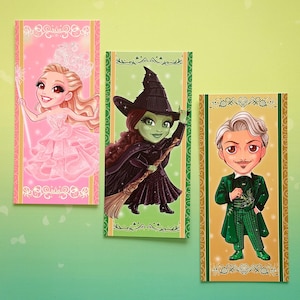 Peut inclure: Trois cartes de personnages illustrés. La première représente une femme blonde en robe rose, la seconde une sorcière à la peau verte en noir, et la troisième un homme en costume vert. Chaque carte a une bordure décorative.