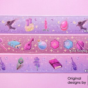 Washi tapes with a pattern of Dungeons and Dragons elements on a purple background. Three rolls are extended showing the patterns:
- amulet, crows, flowers and moons
- dices, bow, axe, shield, book, potion, lute
- book, violin, feather, flowers