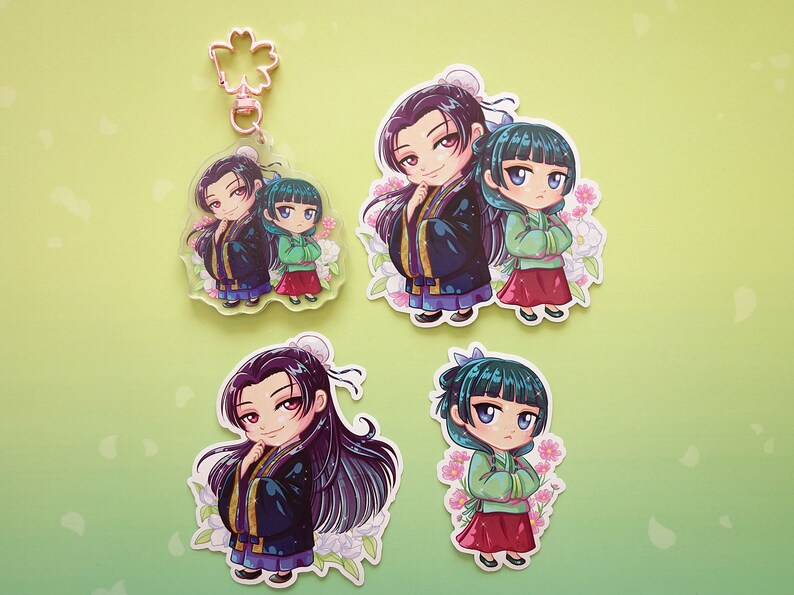 Stickers and keychain with pink flower clasp of Jinshi and Maomao from manga series The Apothecary Diaries.