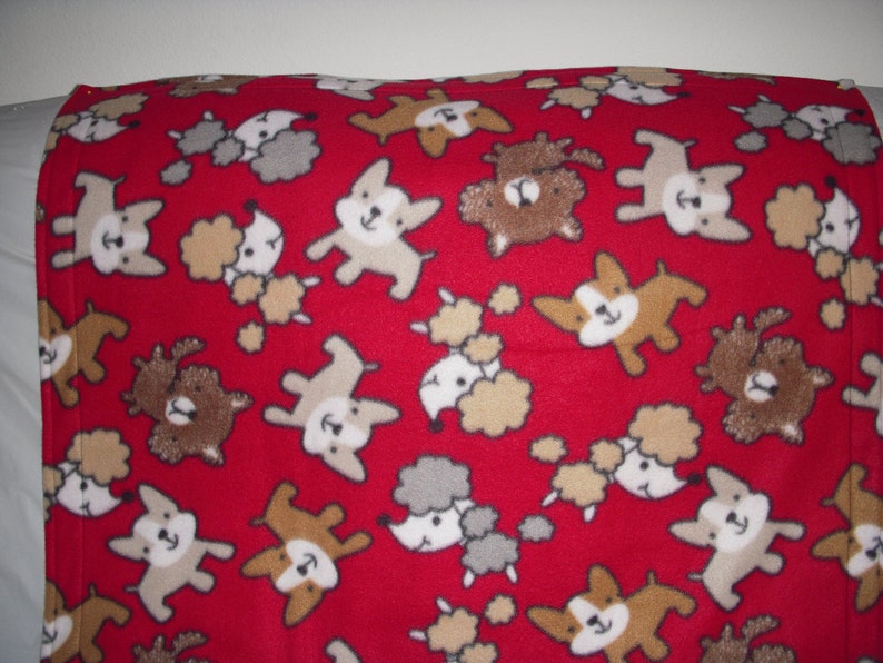 cute little puppies on red print fleece with the same pattern on the reverse side. Doggy Blanket