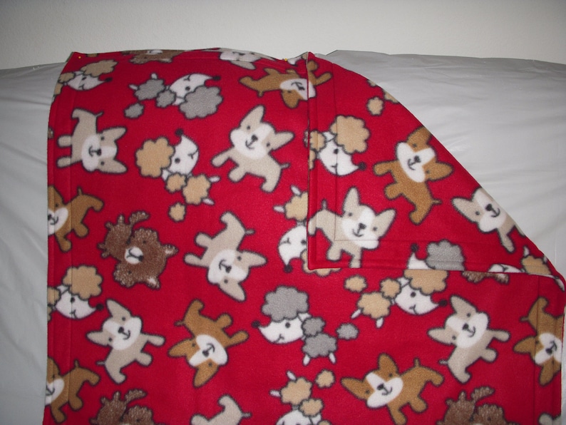 cute little puppies on red print fleece with the same pattern on the reverse side. Doggy Blanket