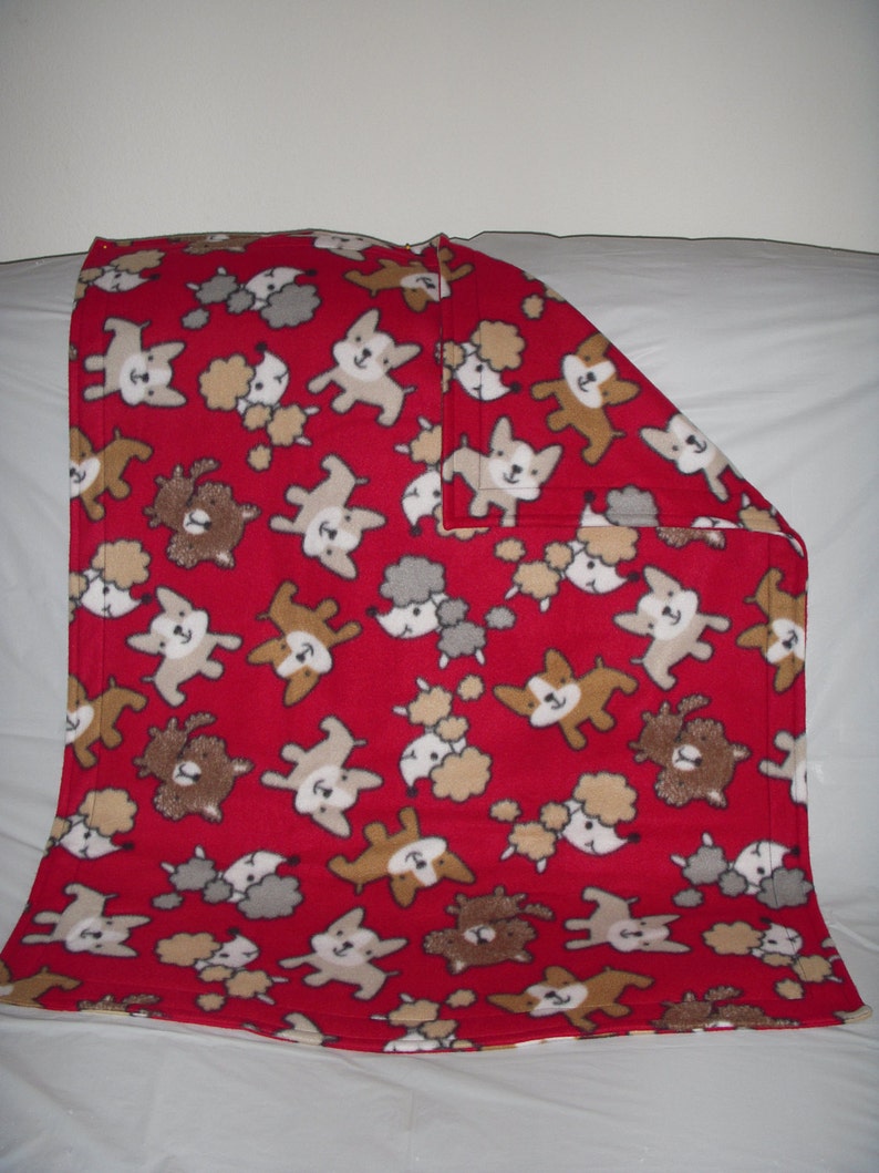 cute little puppies on red print fleece with the same pattern on the reverse side. Doggy Blanket