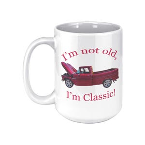 May include: White ceramic mug with a red pickup truck graphic and the text "I'm not old, I'm Classic!"