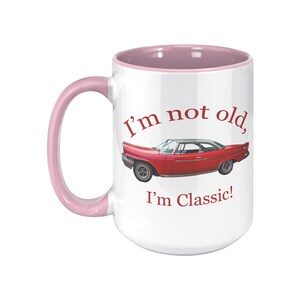 White ceramic mug with vintage 1962 Chrysler 300 photo and 'I'm not old, I'm classic!' quote. Reverse shows '1962 Chrysler 300' text. Options: black, blue, pink, or red handle/interior.
