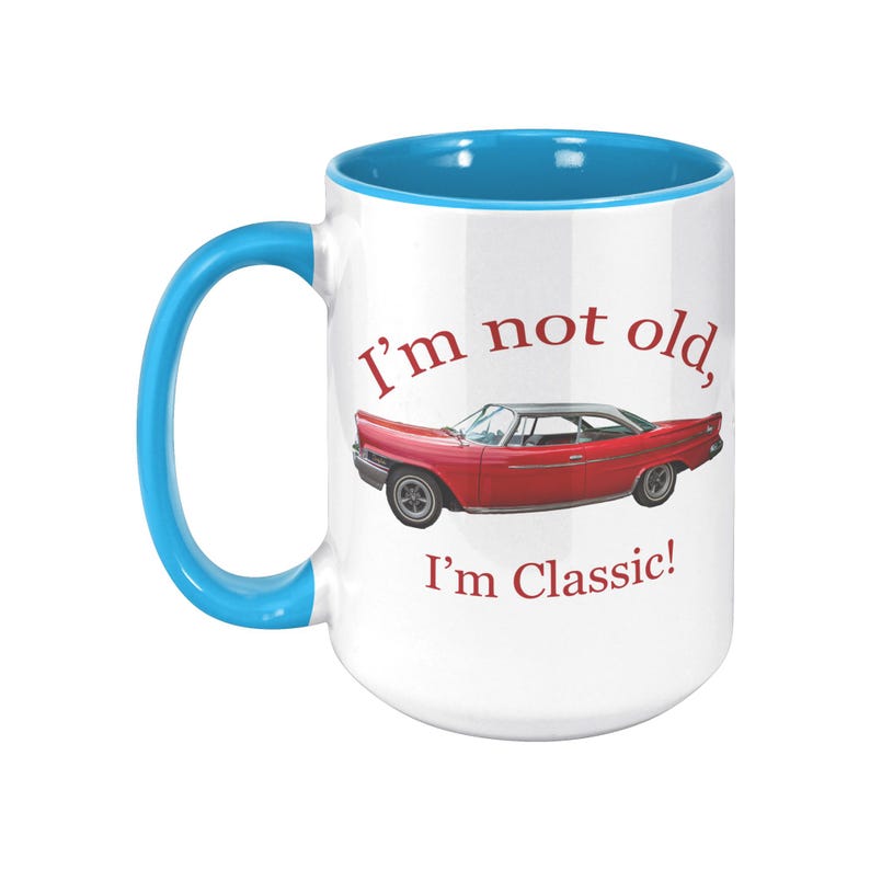 White ceramic mug with vintage 1962 Chrysler 300 photo and 'I'm not old, I'm classic!' quote. Reverse shows '1962 Chrysler 300' text. Options: black, blue, pink, or red handle/interior.