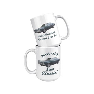 May include: Two white coffee mugs with a green 1969 Pontiac Grand Prix SJ car image. The top mug says "1969 Pontiac Grand Prix SJ". The bottom mug says "Not old, Just Classic!"