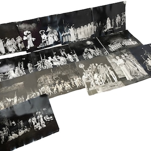 Könnte beinhalten: Eine Sammlung von Vintage-Schwarz-Weiß-Fotografien, die Theateraufführungen darstellen. Die Bilder zeigen kostümierte Figuren in verschiedenen Szenen mit detaillierten Kulissen und Beleuchtung. Die Fotografien sind auf einer weißen Oberfläche angeordnet.