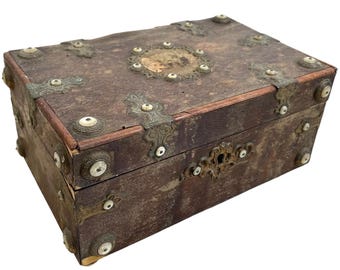 May include: A vintage wooden box with ornate metal accents and bone inlays. The box has a hinged lid and a keyhole. The box is brown and has a distressed finish.