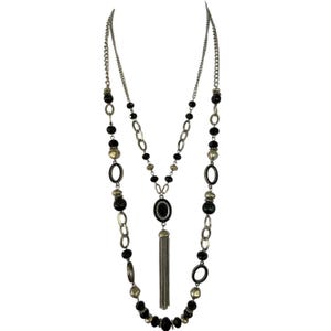 Puede incluir: Un collar largo de varias capas con cadenas plateadas y cuentas negras y doradas. El collar presenta cuentas ovaladas y redondas, con un colgante central y una borla plateada.