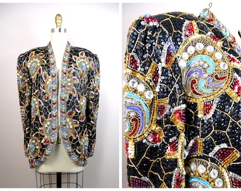 May include: Black sequined jacket with elaborate gold, red, turquoise, and purple beadwork. The jacket features a unique open front design and is displayed on a mannequin. The intricate embellishments create a striking visual effect, perfect for special occasions.