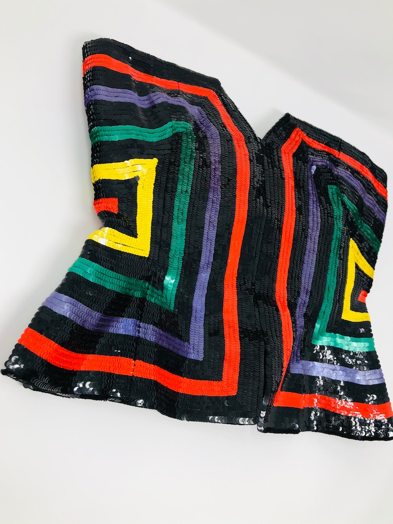 May include: A black sequined top with a geometric pattern in red, green, yellow, and purple.