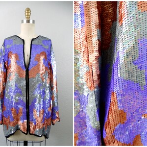 May include: A sequined jacket with a V-neck and long sleeves. The jacket is made of silver, purple, and copper sequins.