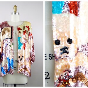 May include: A pink sequined jacket with a multi-colored patchwork design. The jacket features a variety of geometric shapes and animal motifs, including a dog face.