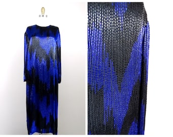 Könnte beinhalten: Ein langärmeliges Kleid aus blauen und schwarzen Pailletten. Die Pailletten sind in einem geometrischen Muster angeordnet.
