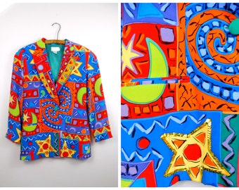 Puede incluir: Una chaqueta de colores con un patrón geométrico con estrellas, lunas y espirales. La chaqueta está hecha de una tela suave y tiene un cierre de doble botonadura.