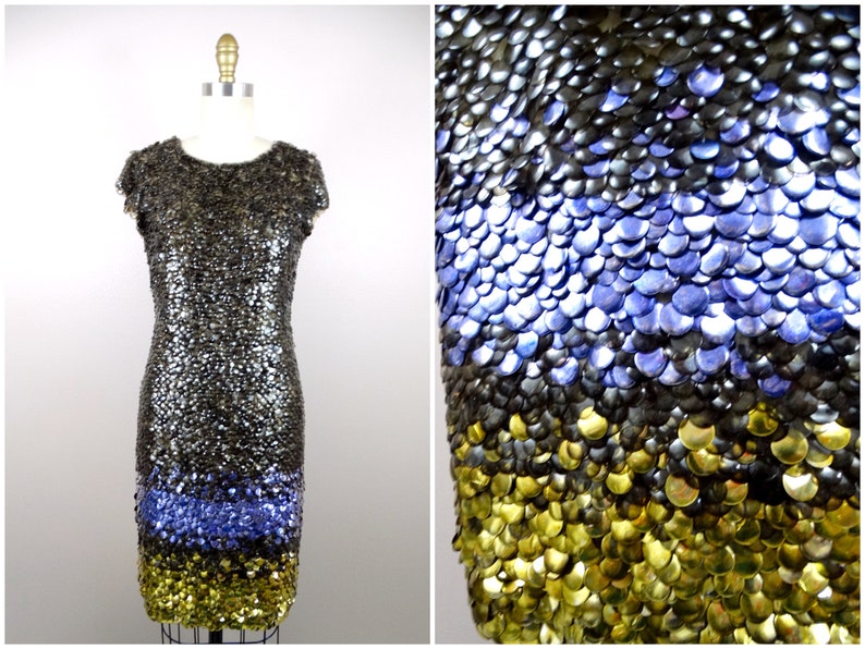 May include: A short, sleeveless dress made of silver, blue and gold sequins. The sequins are arranged in a graduated pattern, with the silver sequins at the top, the blue sequins in the middle and the gold sequins at the bottom.