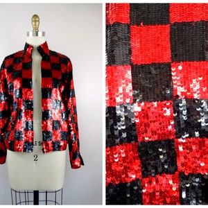 May include: A red and black sequined jacket with a checkered pattern. The jacket has a mandarin collar and long sleeves.