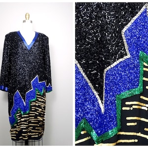May include: A black sequined dress with a V-neckline and long sleeves. The dress features a geometric design with blue, green, and gold sequins.