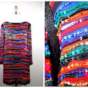 May include: A long-sleeved, sequined dress with a colorful striped pattern. The dress is made of a black fabric with sequins in various colors, including red, blue, green, and gold. The sequins are arranged in a horizontal stripe pattern.
