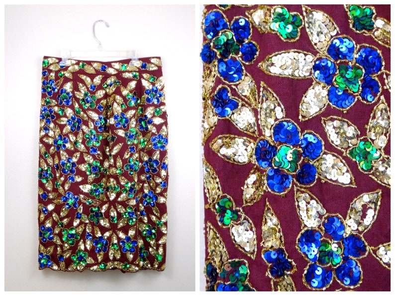 Puede incluir: Una falda color burdeos con un estampado floral hecho de lentejuelas doradas, azules y verdes.