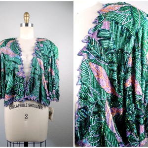May include: A vintage green sequined jacket with a leaf pattern in shades of green, pink, and purple. The jacket has a ruffled edge and is displayed on a mannequin. The style is open-front.