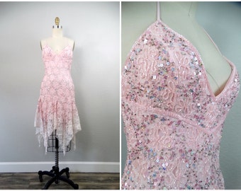 May include: A pink sequined and beaded halter dress with a lace overlay and a high-low hemline.