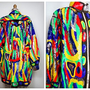 May include: A colourful sequined jacket with a black zip and a geometric pattern in shades of red, yellow, blue, green, and silver.