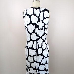 May include: A sleeveless black and white dress with a sequined animal print pattern.