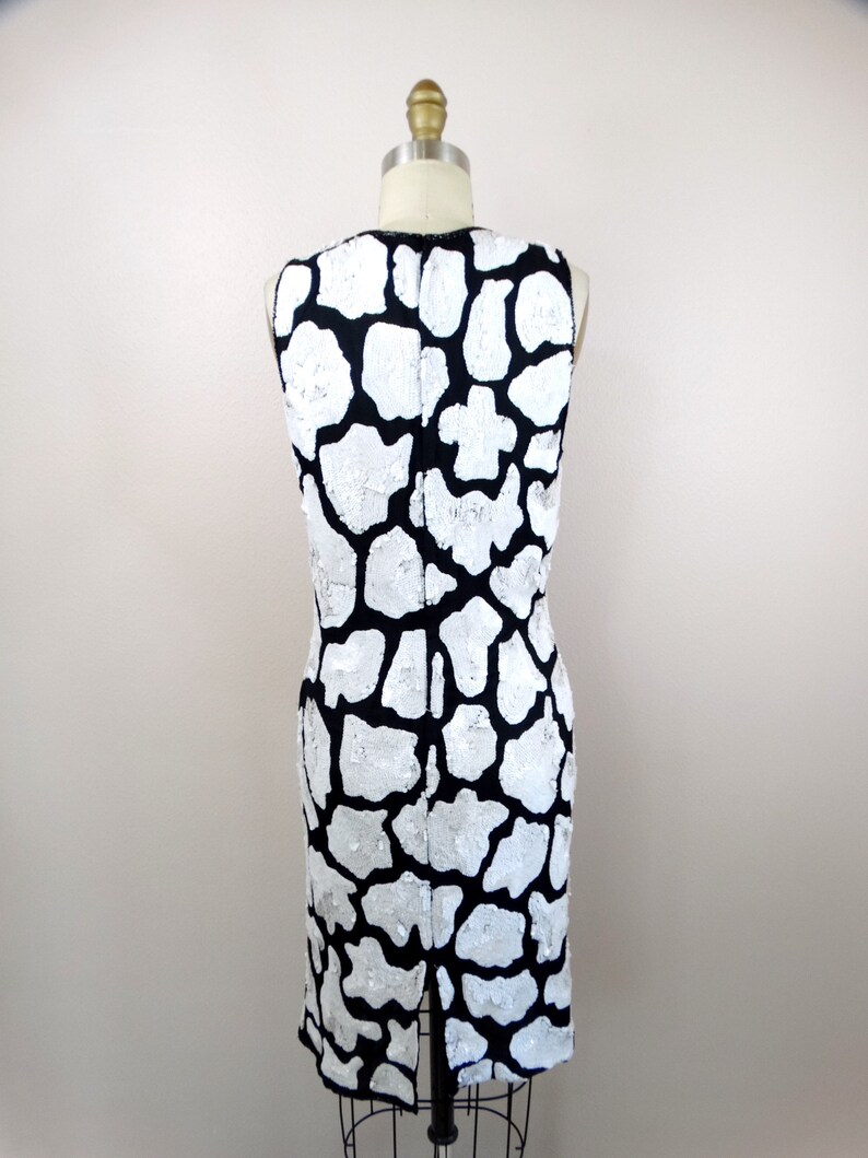 May include: A sleeveless black and white dress with a sequined animal print pattern.