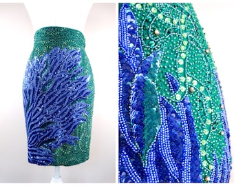 May include: A green and blue sequined skirt with a large blue sequin design on the side.