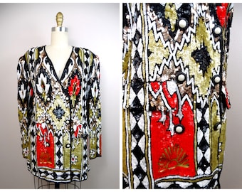 May include: A black, white, red, gold and silver sequined jacket with a geometric pattern. The jacket has a V-neck and long sleeves. It features a double-breasted closure with large buttons.