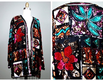 May include: A black sequined jacket with a patchwork design featuring geometric shapes, flowers, and leaves. The jacket has a long, open front and is adorned with sequins in shades of gold, silver, red, pink, orange, turquoise, and black.