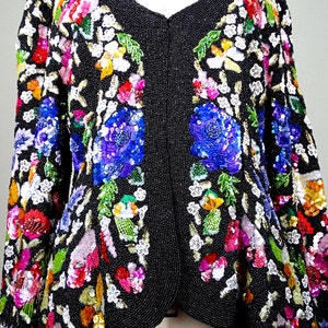 Pode incluir: Uma jaqueta preta de contas com um design floral. A jaqueta &eacute; adornada com lantejoulas e contas coloridas, criando um padr&atilde;o vibrante e intrincado.