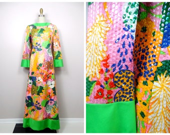 Pode incluir: Um vestido maxi longo com estampa floral rosa, verde e multicolorido com uma bainha verde. O vestido é feito de um tecido texturizado com lantejoulas.