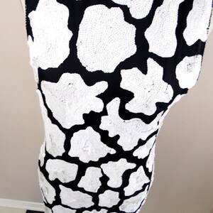 May include: A sleeveless black and white dress with a sequined animal print pattern.