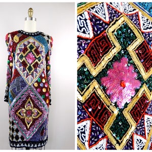 Puede incluir: Un vestido de manga larga con un patrón geométrico hecho de lentejuelas y cuentas. El vestido es en tonos de rojo, verde, azul, dorado y rosa.