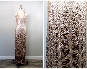 May include: A long, sequined evening gown with a V-neckline and a gradient of gold and brown sequins.