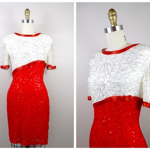 May include: A sequined dress with a white top and a red bottom. The white portion has silver embellishments and short sleeves. The dress is displayed on a mannequin. The neckline and sleeve edges are trimmed in red.