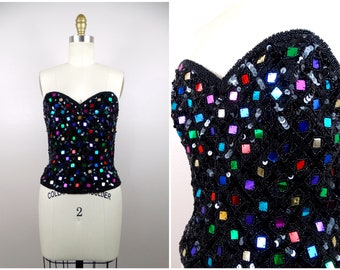 May include: A black strapless top with a sweetheart neckline, covered in colorful square sequins.