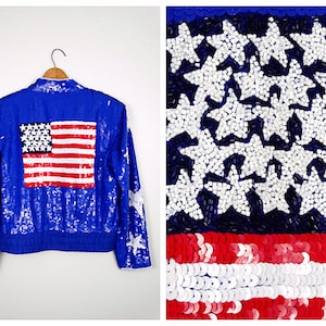 May include: A blue sequined jacket with a red, white, and blue American flag on the back. The jacket is decorated with white stars.