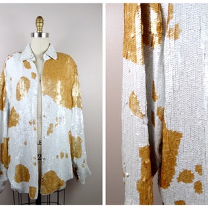May include: A white and gold sequined jacket with a button-up front. The jacket has a cowhide pattern.
